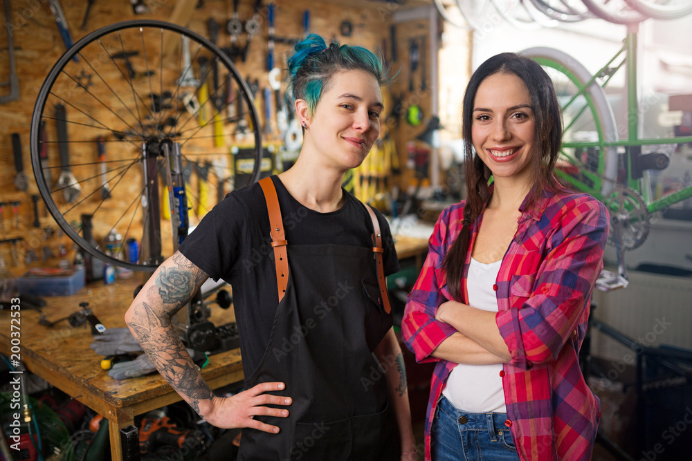 Obraz premium Two young women working in a bicycle repair shop 