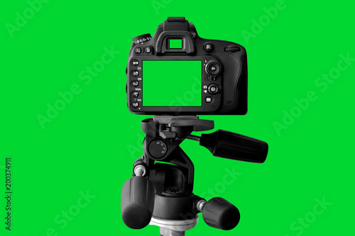 The Dslr camera with green screen on the tripod isolated on green background. The chromakey. Green screen.
