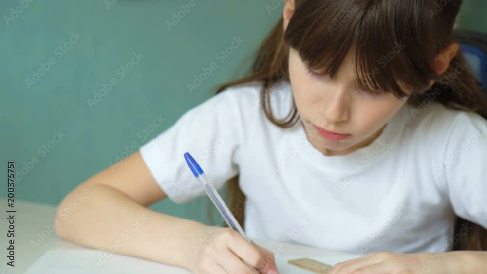 Girl learning lessons, cute shoolgirl making her homework, at home Girl learning lessons, cute shoolgirl making her homework, at home
