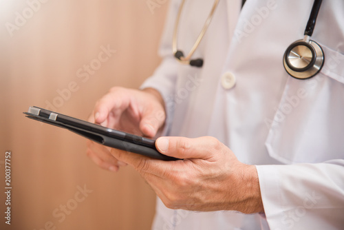 Doctor hands using and pointing on digital tablet.