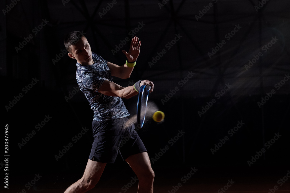 young professional tennis player with a blue racket hitting a forehand, black background, wet ball creating a splash young professional tennis player with a blue racket hitting a forehand, black background, wet ball creating a splash
