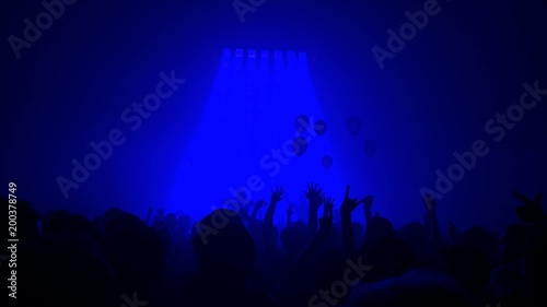 Ombres de foule mains levées et ballons à un concert (fond bleu)