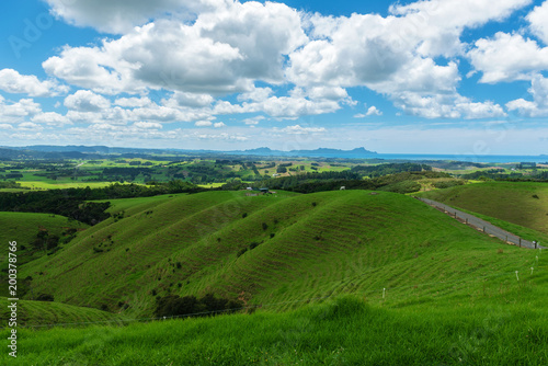 Rolling hills and meadows under a blue sky filled with clouds