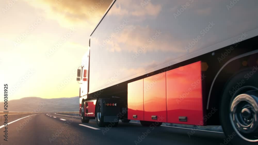 semi trailer truck driving along a desert road into the sunset