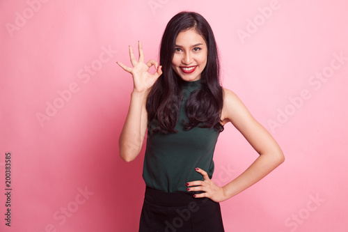 Young Asian woman show OK sign.