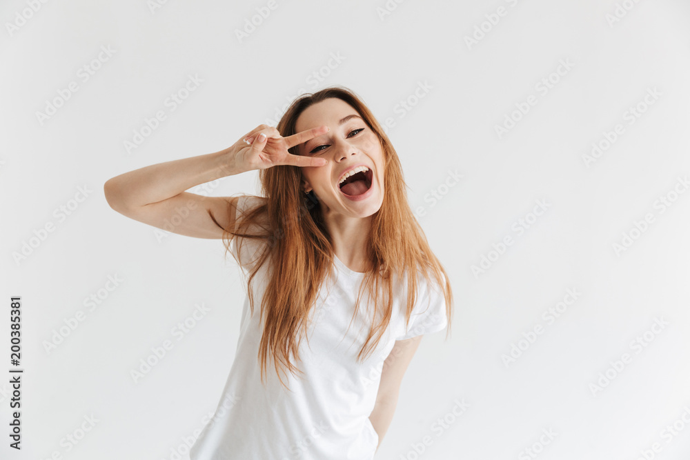 Cheerful woman in t-shirt showing peace gesture Cheerful woman in t-shirt showing peace gesture