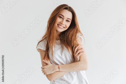 Happy woman in t-shirt posing with crossed arms