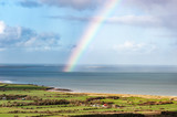 Irish rural landscape with rainbow over the atlantic ocean