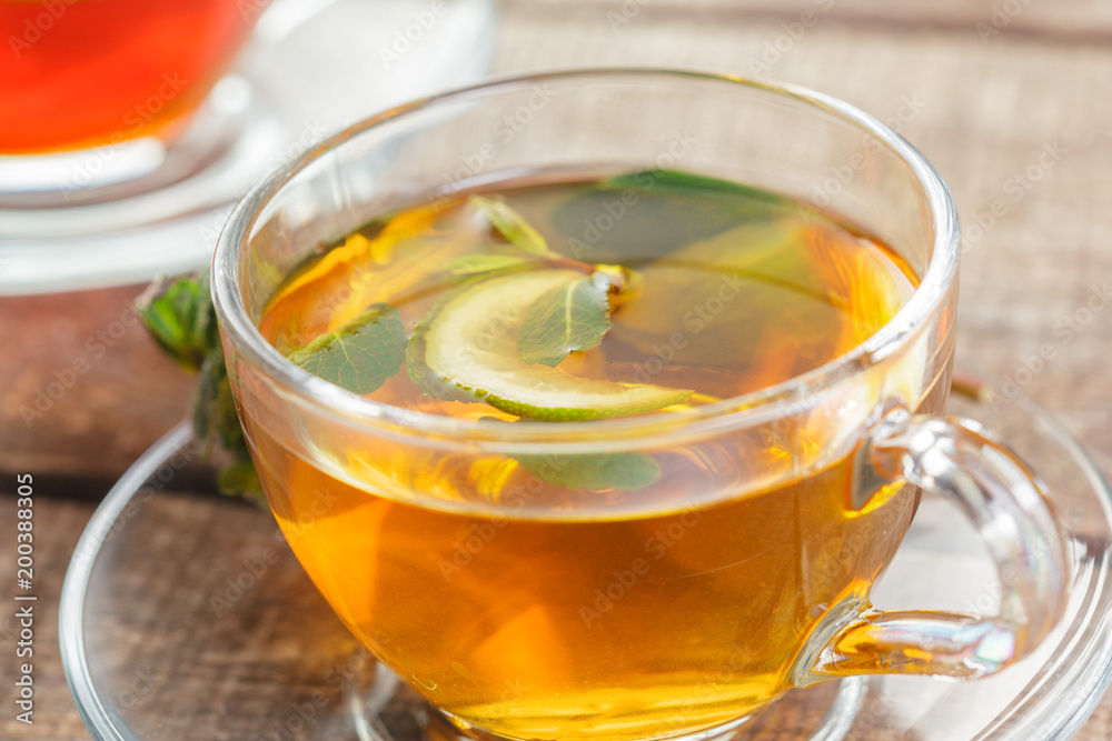 cup of black tea with mint leaves on a wooden table cup of black tea with mint leaves on a wooden table