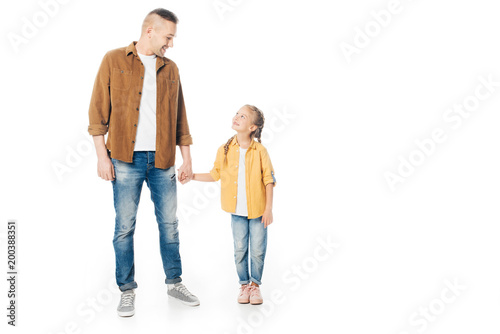 father and little daughter looking at each other and holding hands isolated on white