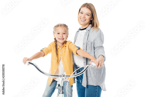 portrait of smiling mother and cute daughter on bicycle isolated on white