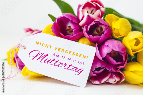 Greeting card - Pink and yellow tulips on a wooden background