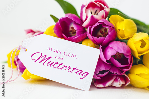 Greeting card - Pink and yellow tulips on a wooden background