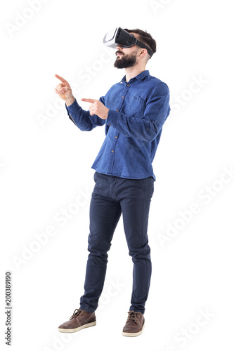 Side view of bearded business man gesticulating with hand and finger having virtual reality experience. Full body isolated on white background. 