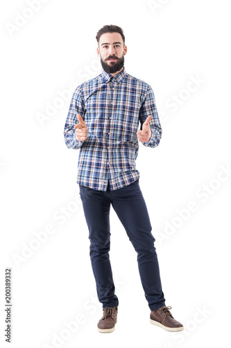Bearded business man in plaid shirt pointing with amused expression looking at camera. Full body isolated on white background. 