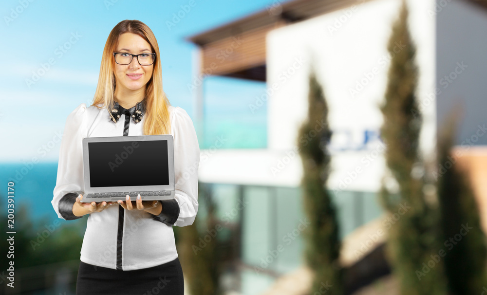 Young woman standing with laptop laptop in her hands