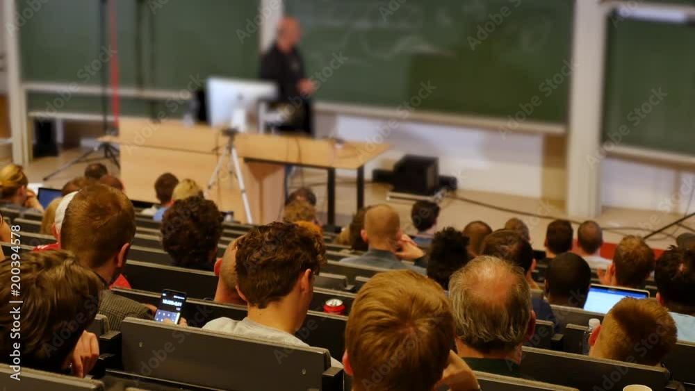 Professor or teacher delivers a lecture college to a large audience of students 