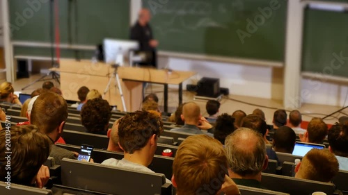 Professor or teacher delivers a lecture college to a large audience of students  photo