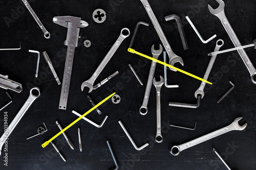 Tools scattered in a chaotic manner on black background. Top view