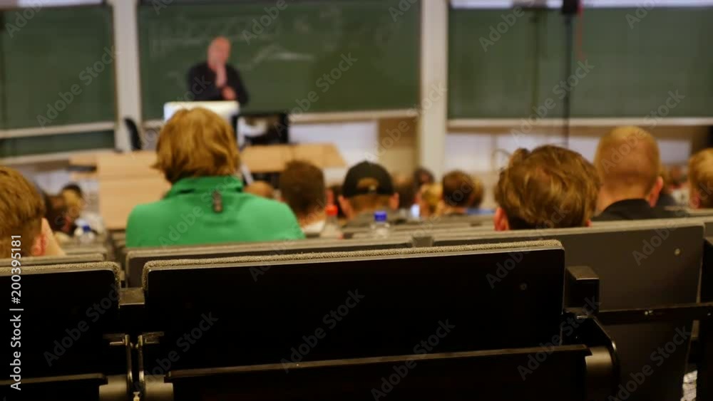 Professor or teacher delivers a lecture college to a large audience of students Professor or teacher delivers a lecture college to a large audience of students