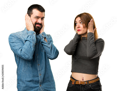 Man and woman covering their ears