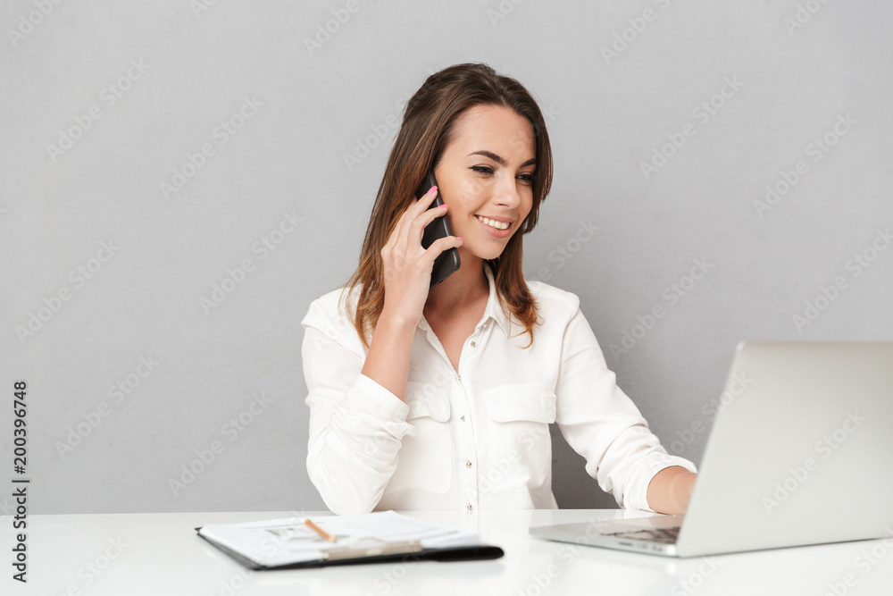Portrait of a happy young business woman using mobile phone isolated over white background Portrait of a happy young business woman using mobile phone isolated over white background