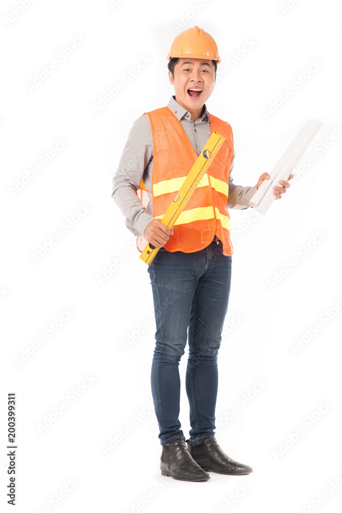 Fototapeta premium Studio portrait of construction worker in orange waistcoat and hardhat holding levelling tool and building plan