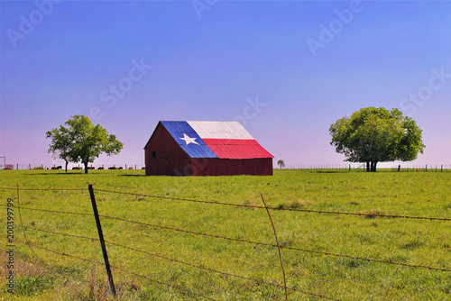 A barn on a Texas ranch with the state flag painted on the roof