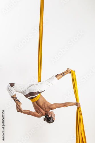 Man making acrobatic dance with fabrics