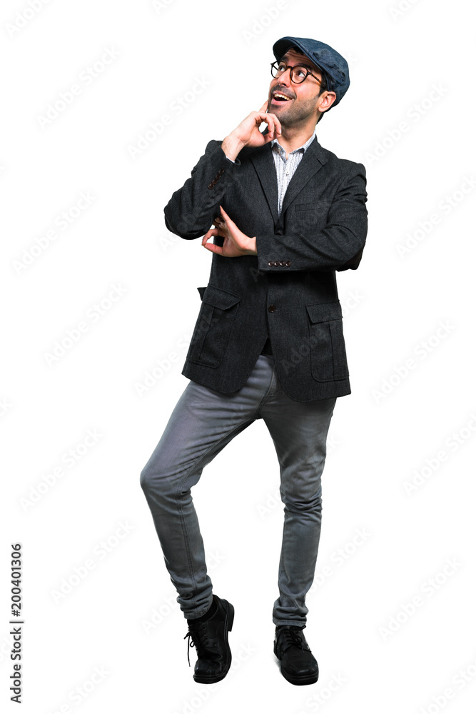 Handsome modern man with beret and glasses standing and thinking an idea Handsome modern man with beret and glasses standing and thinking an idea