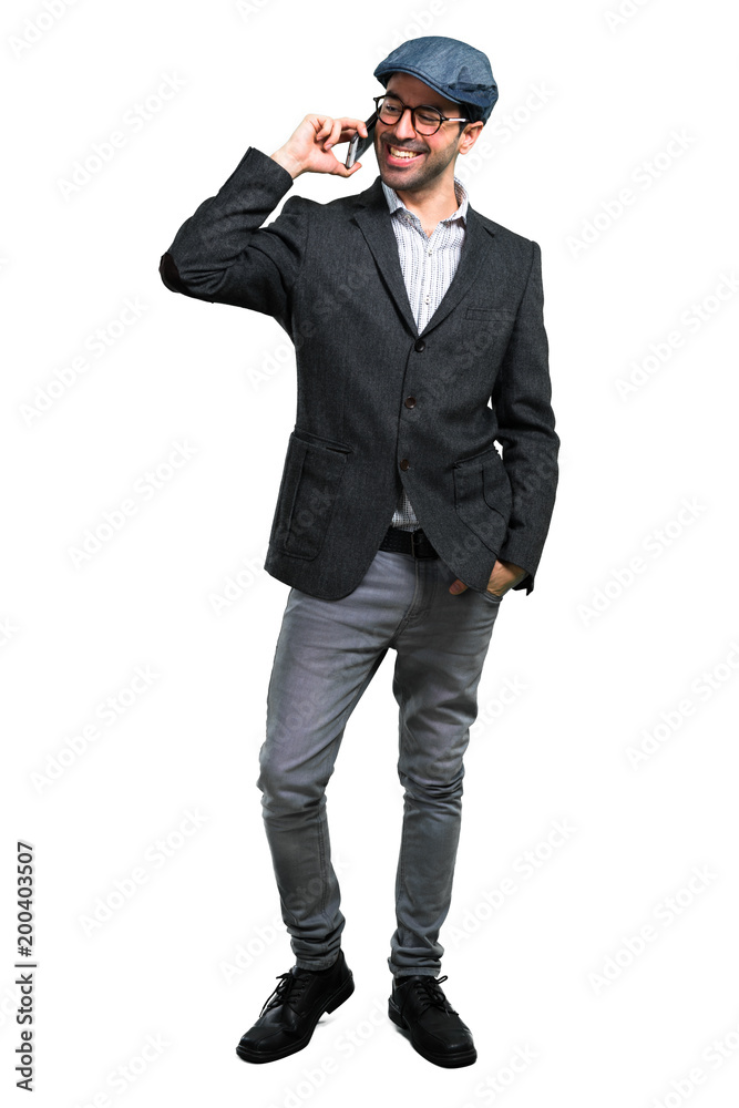 Handsome modern man with beret and glasses talking to mobile Handsome modern man with beret and glasses talking to mobile