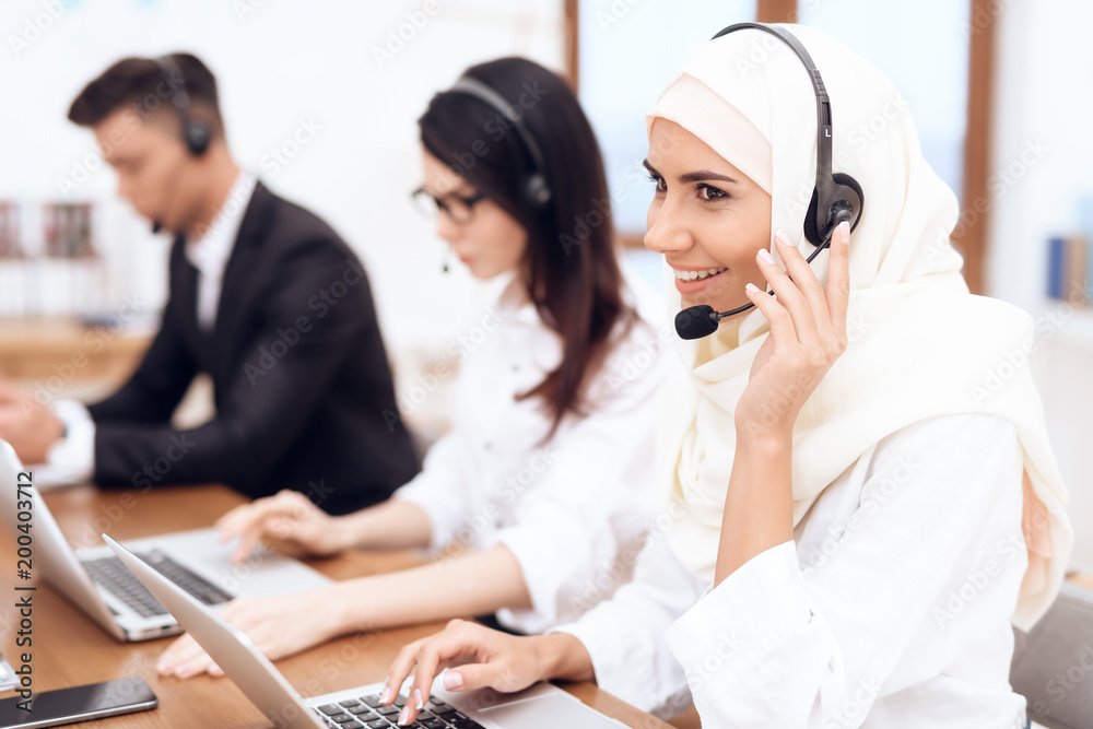 An Arab woman works in a call center. An Arab woman works in a call center.