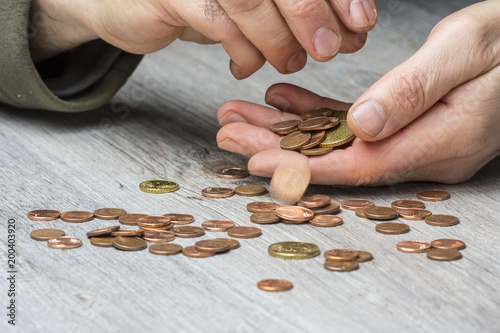 Un homme en précarité compte sa petite monnaie 