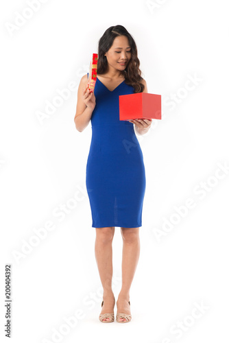 Portrait of elegant Asian woman in blue dress holding red gift box