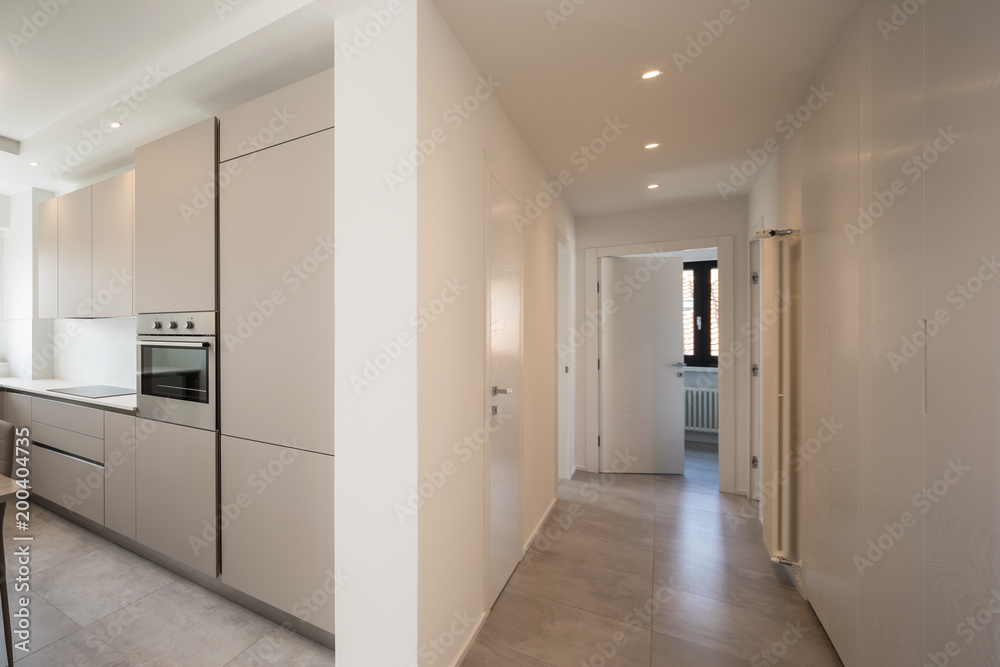 Elegant kitchen and corridor with spotlights in modern apartment Elegant kitchen and corridor with spotlights in modern apartment