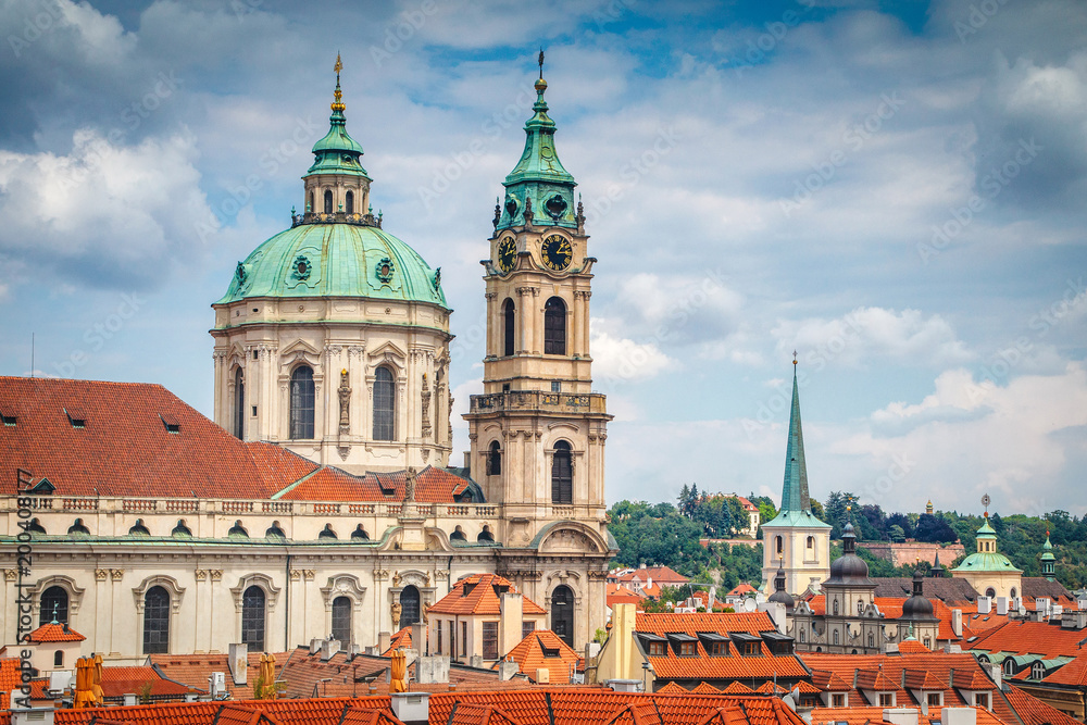 Beautiful summer view on Church of St. Nicholas red tile roofs in Prague from Vrtba garden