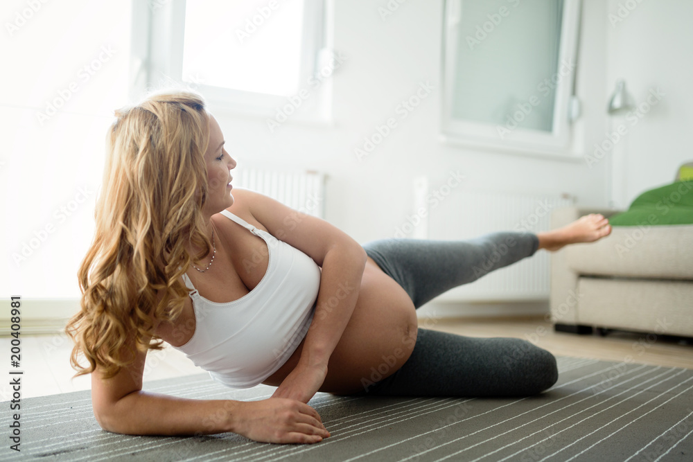 Sporty pregnant woman doing exercises at home Sporty pregnant woman doing exercises at home