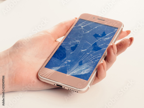 Broken glass blue screen of rose smartphone in hand, white background