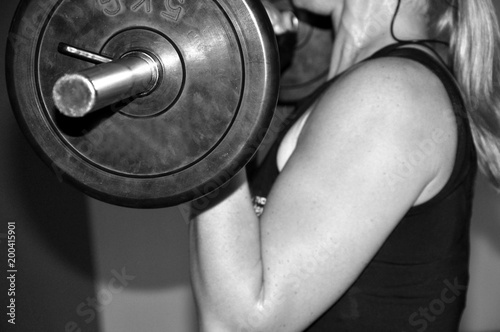 Bizepscurls mit der Langhantel, Training für den Muskelaufbau, starke Frau. photo