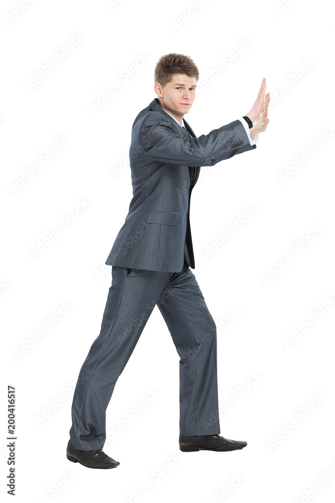 in full growth. modern businessman,moving the wall with his hands, in full growth. modern businessman,moving the wall with his hands,
