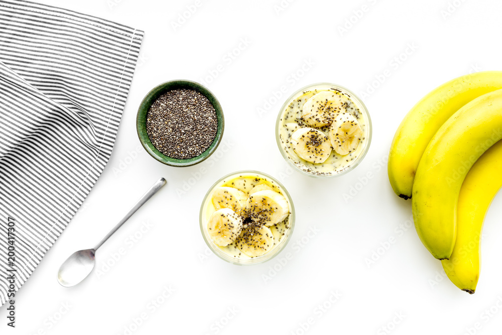 Light healthy snack. Banana pudding with chia seeds on white table with blue tablecloth top view