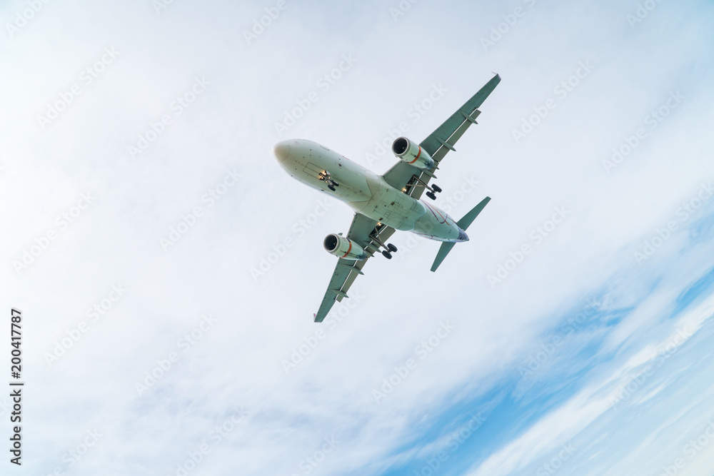Fototapeta premium Airplane aircraft flying, landing in the good weather at blue cloudy sky