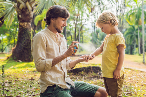 Foto dad and son use mosquito spray