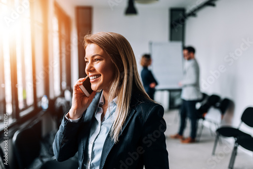 Close-up image of smiling businesswoman talking on a cellphone.