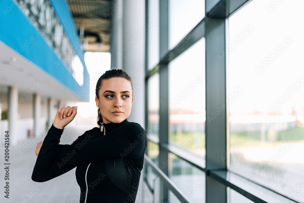 Fototapeta premium Close up image of fit girl stretching indoors.