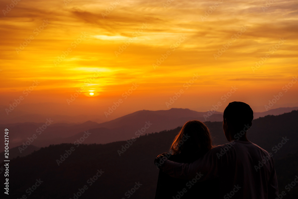 silhouette Couple lover with mountains landscape in beautiful sunset sky