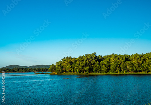 little island in the lake with mountain and blue sky