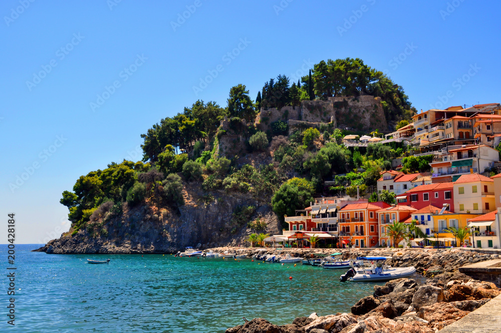 Parga, Epirus - Greece. Colorful houses amphitheatrically built next to the castle of Parga. Sunny day with clear blue sky