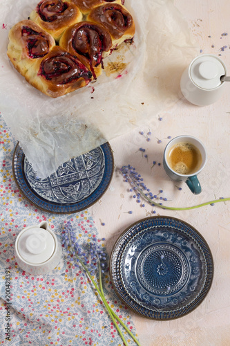 Blackberries buns. White background and blue plates. Coffee and flowers.