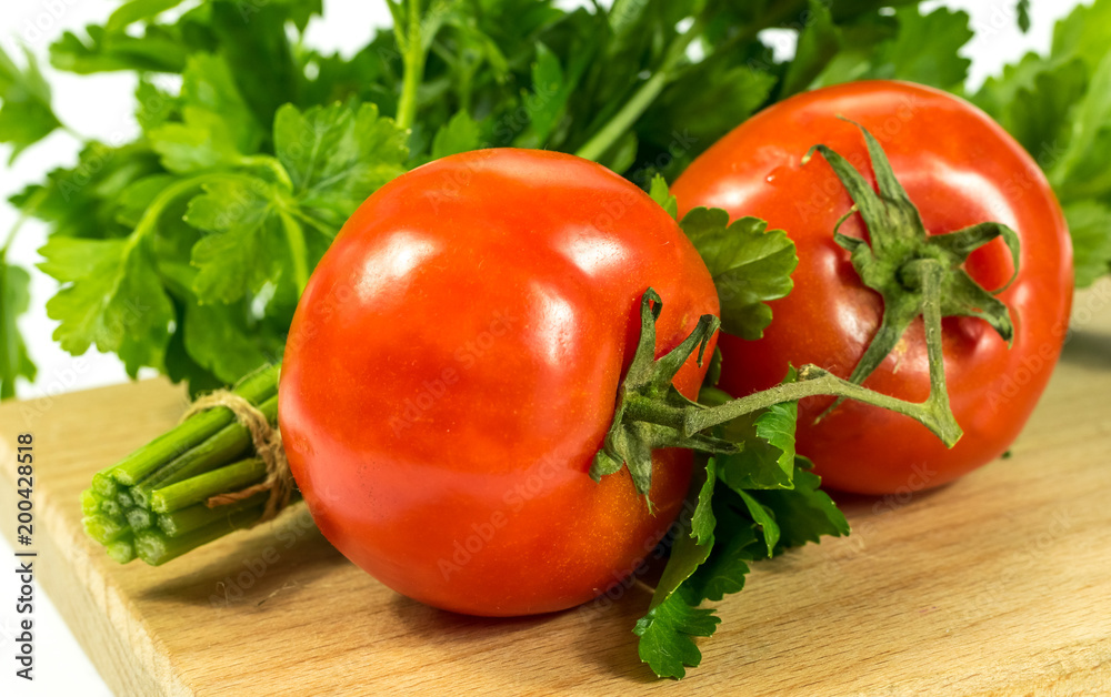 Ripe juicy tomatoes and parsley on a cutting board Ripe juicy tomatoes and parsley on a cutting board